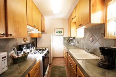 a kitchen with wooden cabinets and a stove top oven at The Emerald Iguana Inn in Ojai
