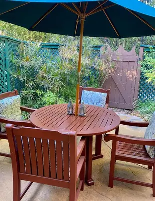 a wooden table with an umbrella on a patio at The Emerald Iguana Inn in Ojai