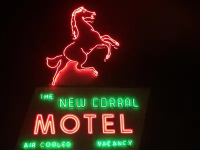 a neon sign for the new corral motel at New Corral Motel in Victorville