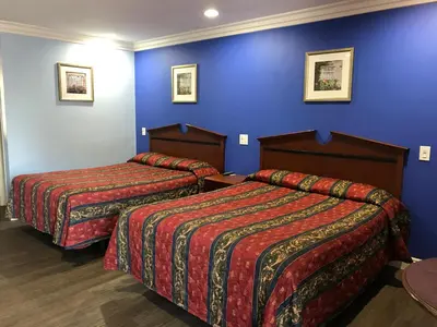 two beds in a hotel room with blue walls at Fullerton Lodge in Fullerton