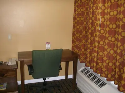 a desk with a green chair and a desk with a phone at Fullerton Lodge in Fullerton