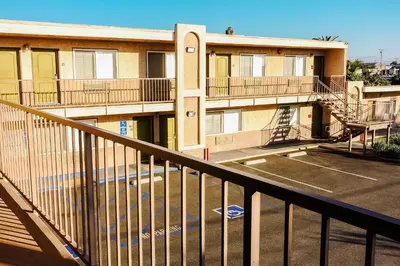 an apartment building with stairs and a parking lot at Tropic Lodge in Anaheim