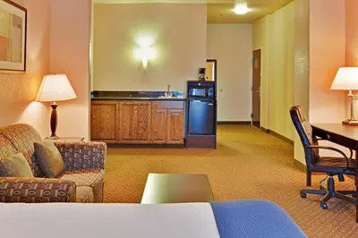 a hotel room with a couch and a kitchen at Holiday Inn Express Delano Highway 99 by IHG in Delano