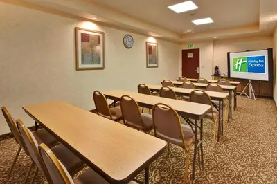 a conference room with tables and chairs and a screen at Holiday Inn Express Delano Highway 99 by IHG in Delano