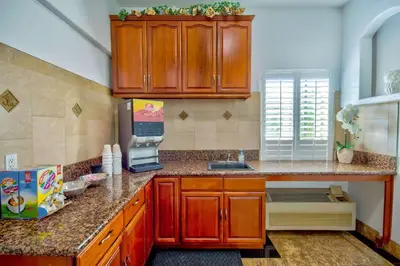a kitchen with wooden cabinets and a counter top at Motel 6-Inglewood, CA in Inglewood