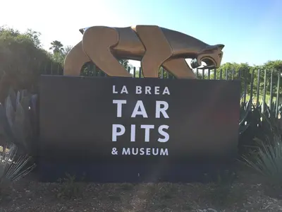 a sign for la brea tar pits and museum at American Inn Downey in Downey