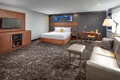 a hotel room with a bed and a couch at Studio Inn & Suites at Promenade Downey in Downey