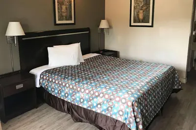 a hotel room with a bed with a colorful blanket at Rodeway Inn Ontario Mills Mall in Guasti