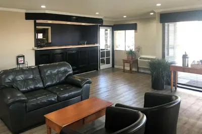 a living room with a leather couch and a table at Rodeway Inn Ontario Mills Mall in Guasti
