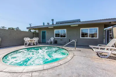 a small swimming pool with chairs and a house at Rodeway Inn Ontario Mills Mall in Guasti