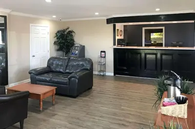 a living room with a leather couch and a table at Rodeway Inn Ontario Mills Mall in Guasti