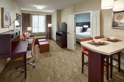 a hotel room with a desk and a living room at Staybridge Suites Anaheim At The Park by IHG in Anaheim