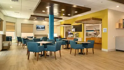 a waiting room with tables and chairs in a hospital at Holiday Inn Express Fullerton-Anaheim by IHG in Fullerton