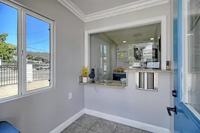a bathroom with a sink and a large window at White Caps Motel in Ventura