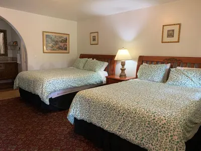 a hotel room with two beds and a lamp at Chantico Inn in Ojai