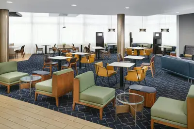 a waiting area with tables and chairs and tablesktop at Courtyard by Marriott Los Angeles Woodland Hills in Woodland Hills