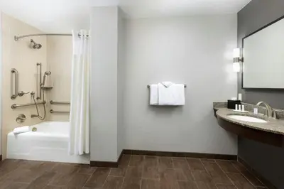 a bathroom with a tub and a shower and a sink at Courtyard by Marriott Los Angeles Woodland Hills in Woodland Hills