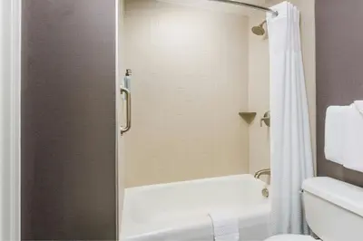 a bathroom with a shower and a white tub at Courtyard by Marriott Los Angeles Woodland Hills in Woodland Hills
