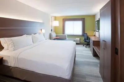 a hotel room with a large bed and a desk at Holiday Inn Express & Suites Woodland Hills by IHG in Woodland Hills