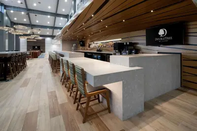 a restaurant with a counter with chairs and a bar at DoubleTree by Hilton Bakersfield in Bakersfield