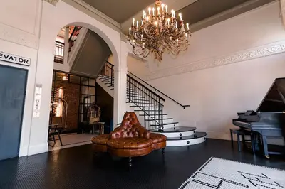 a living room with a chair and a chandelier at H by H Hospitality in Los Angeles