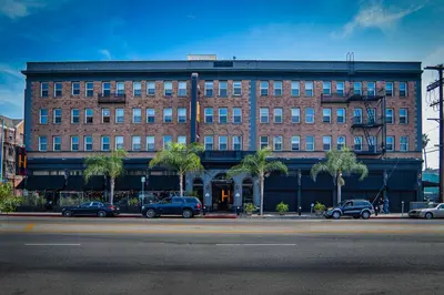 a large brick building with cars parked in front of it at H by H Hospitality in Los Angeles