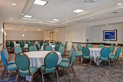 a conference room with tables and chairs and a screen at Hilton Garden Inn San Bernardino in San Bernardino