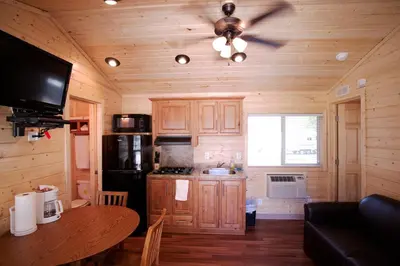 a kitchen with wooden cabinets and a ceiling fan at Soledad Canyon Cottage 5 in Ravenna