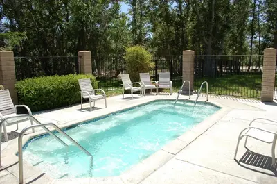 a small swimming pool with chairs and a fence at Soledad Canyon Studio Cabin 21 in Ravenna