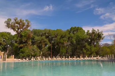a swimming pool with chairs and trees in the background at Soledad Canyon Deluxe Cabin 23 in Ravenna