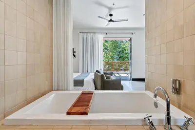 a bathtub in a bathroom with a living room at Hotel Casa 425 + Lounge, A Four Sisters Inn in Claremont