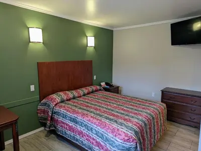 a hotel room with a bed and a dresser at Americas Best Value Inn Oxnard-Port Hueneme in Port Hueneme