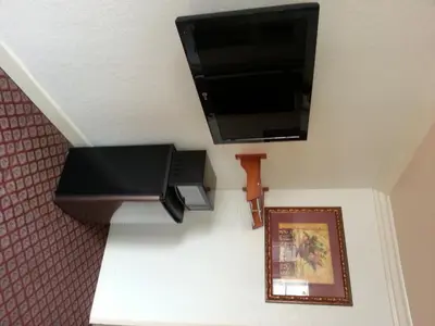 a flat screen tv hanging on a wall with a picture at Walls Motel Long Beach in Long Beach