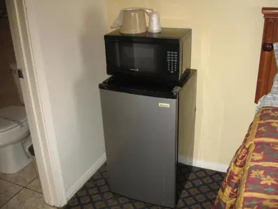 a microwave sitting on top of a small refrigerator at Tower Motel Long Beach in Long Beach
