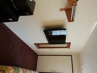 a bedroom with a garage door and a tv on the ceiling at Tower Motel Long Beach in Long Beach