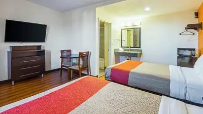 a hotel room with two beds and a flat screen tv at Motel 6 Maple/Main in Hesperia