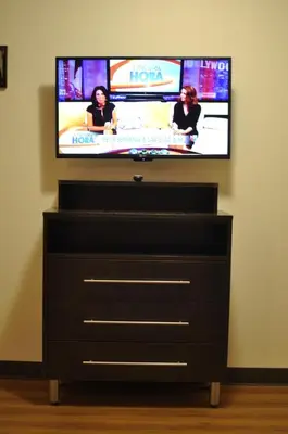 a flat screen tv sitting on top of a dresser at Motel 6 Maple/Main in Hesperia
