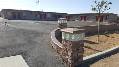 a brick wall in front of a parking lot at Motel 6 Maple/Main in Hesperia