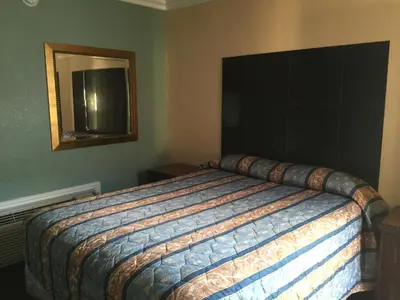 a bedroom with a large bed with a mirror at Park Motel in Los Angeles