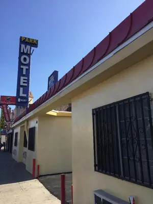 a sign on the side of a building with a gate at Park Motel in Los Angeles