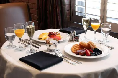 a table with plates of food and glasses of wine at The Mission Inn Hotel and Spa in Riverside
