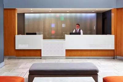 a man standing behind a counter in a lobby at Best Western Plus Meridian Inn & Suites, Anaheim-Orange in Orange