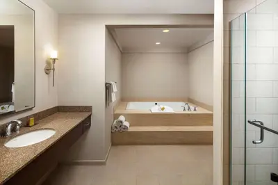 a bathroom with a bath tub and a sink at DoubleTree by Hilton Ontario Airport in Ontario