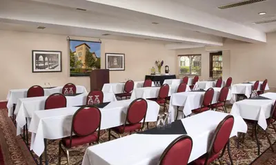 a conference room with white tables and red chairs at Ayres Suites Ontario at the Mills Mall - Rancho Cucamonga in Ontario
