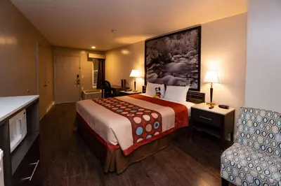 a hotel room with a large bed and a couch at Super 8 by Wyndham Anaheim/Disneyland Drive in Anaheim