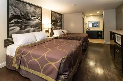 a hotel room with two beds and a flat screen tv at Super 8 by Wyndham Anaheim/Disneyland Drive in Anaheim