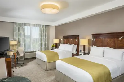 a hotel room with two beds and a flat screen tv at Ayres Hotel Anaheim in Anaheim