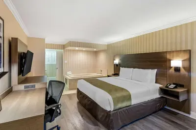 a hotel room with a large bed and a bathroom at Quality Inn & Suites Anaheim Maingate in Anaheim
