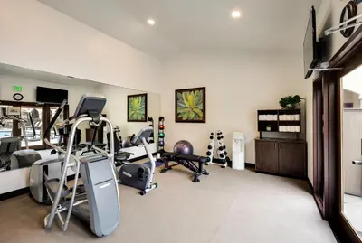 a gym with treadmills and exercise equipment in a room at Ayres Hotel Redlands - Loma Linda in Redlands