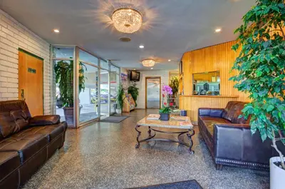a living room with leather couches and a coffee table at Dunes Inn - Wilshire in Los Angeles